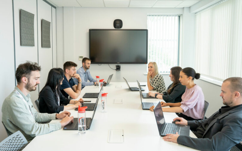 image of conference room with people sitting around the table